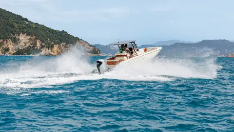 Modeller på baksidan av båten med BF350-motor i havsmiljö.