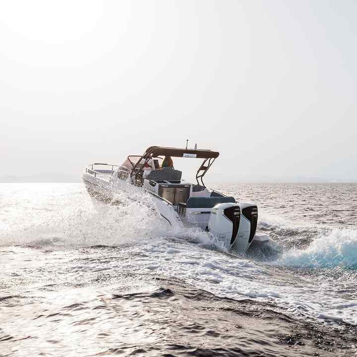 Två modeller som kör en båt med Honda BF350 v8-motor på havet.