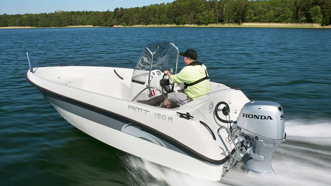 Båt med BF50-motor, använd av modell, kustmiljö.
