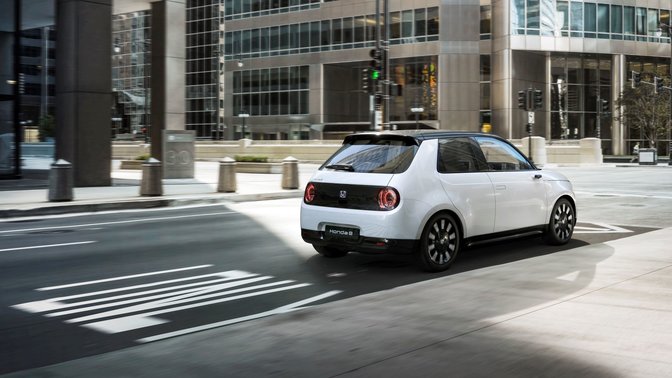 Trekvartsvy bakifrån av Honda-e på en gata med trafikljus