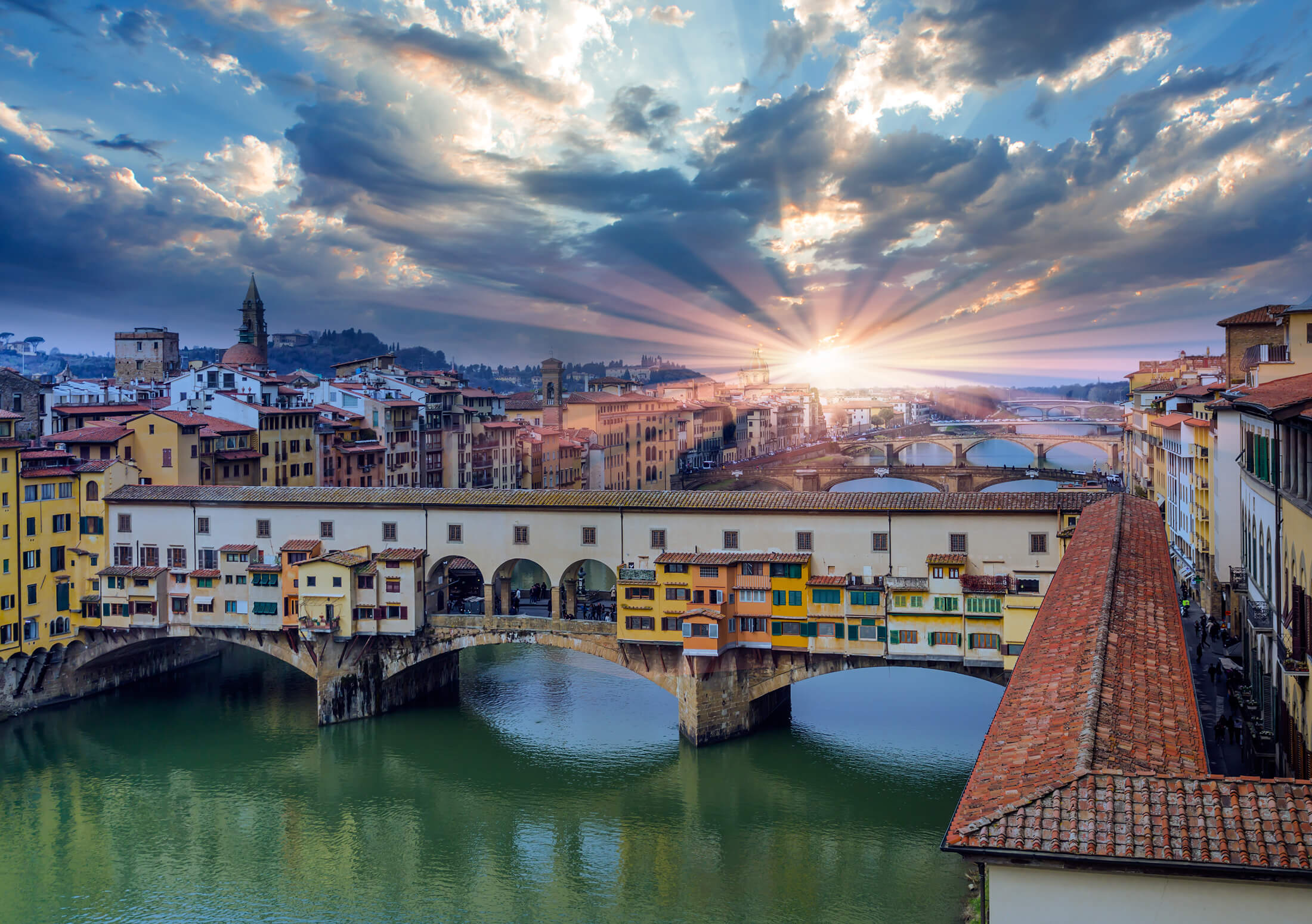 Solen ovanför Ponte Vecchio i Florens, Italien