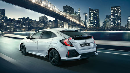 Bild snett bakifrån av Honda Civic Dynamic i stadsmiljö.