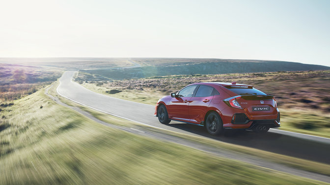 Bild snett bakifrån av Honda Civic. Landsbygdsmiljö.