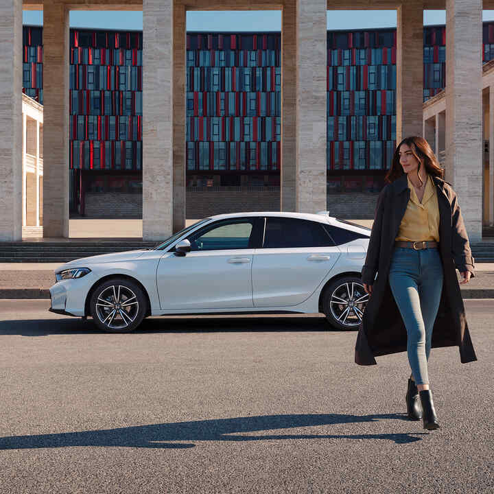Kvinna som går framför Civic Hybrid.
