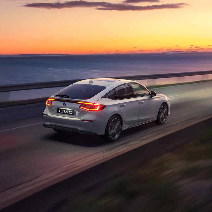 Civic Hybrid-bil kör i solnedgången.