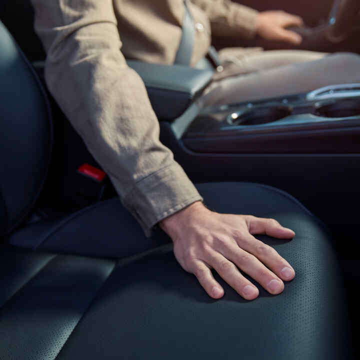 Närbild på en person med en hand på sätet på en Honda Civic Hybrid.