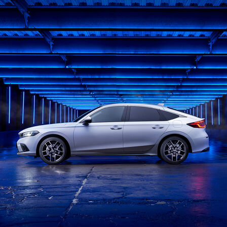Vy från sidan av Honda Civic e:HEV parkerad på en sidogata.