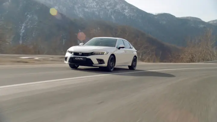 Front facing Honda Civic Hybrid driving down the road. 