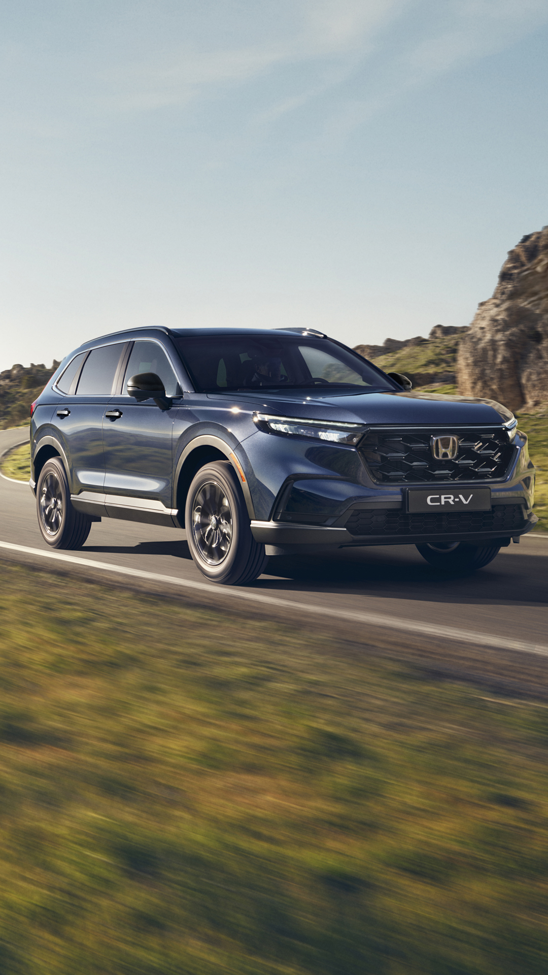 CR-V Plug in Hybrid Suv car driving on the road in a mountain location.