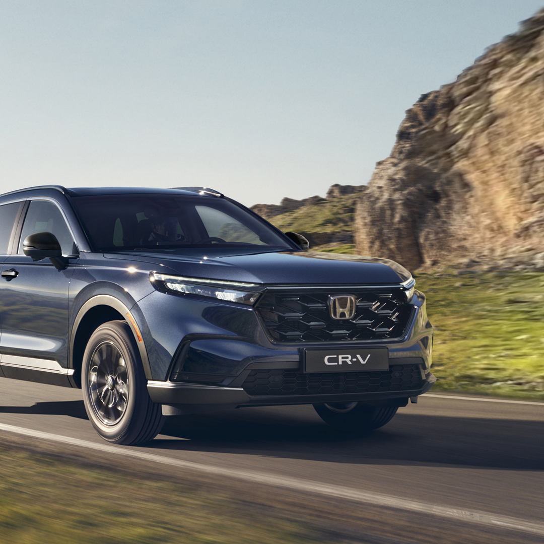 Vy snett framifrån av Honda CR-V Hybrid som kör i bergsmiljö.