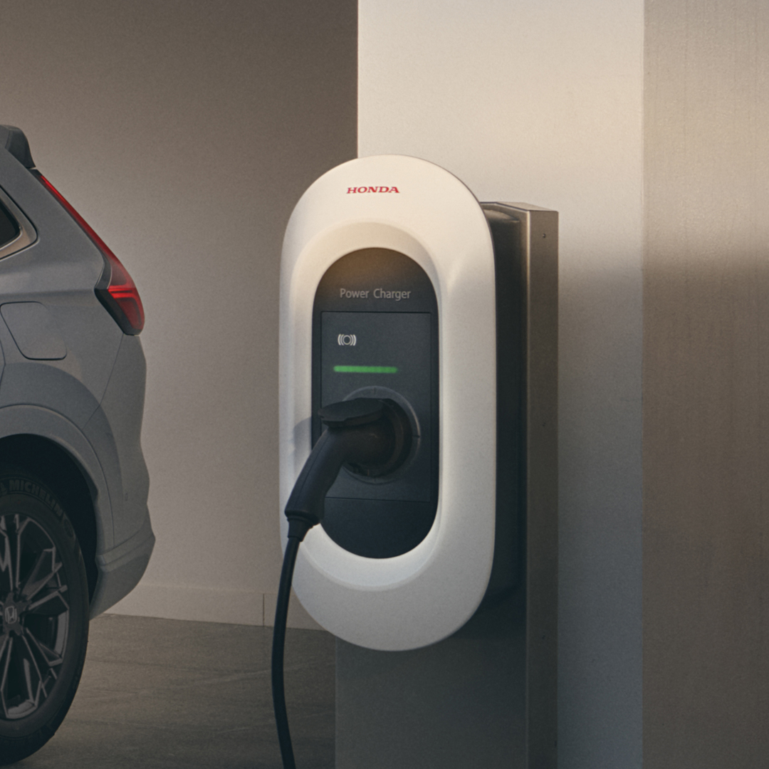 Vy snett framifrån av Honda CR-V Hybrid inkopplad för laddning.