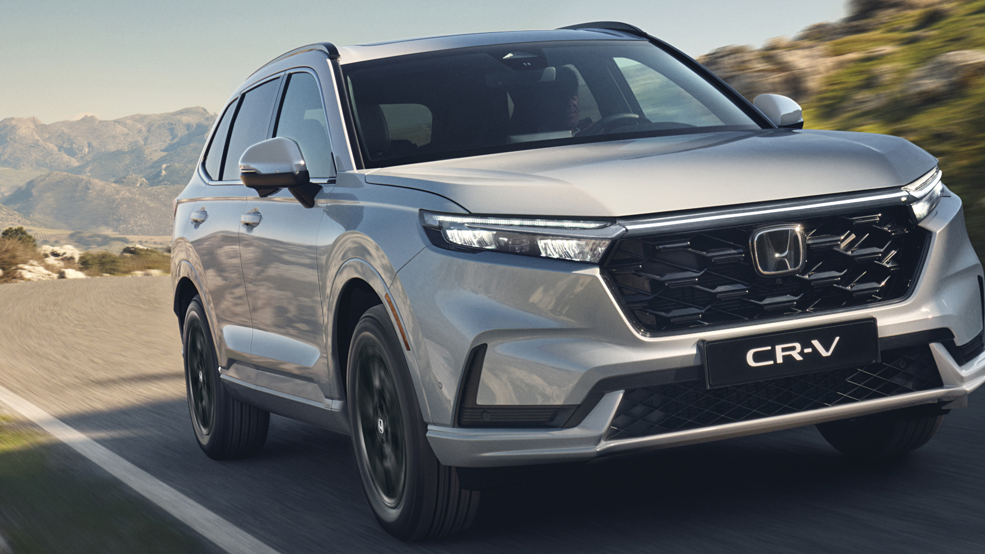 Vy snett framifrån av Honda CR-V Hybrid i bergsmiljö.