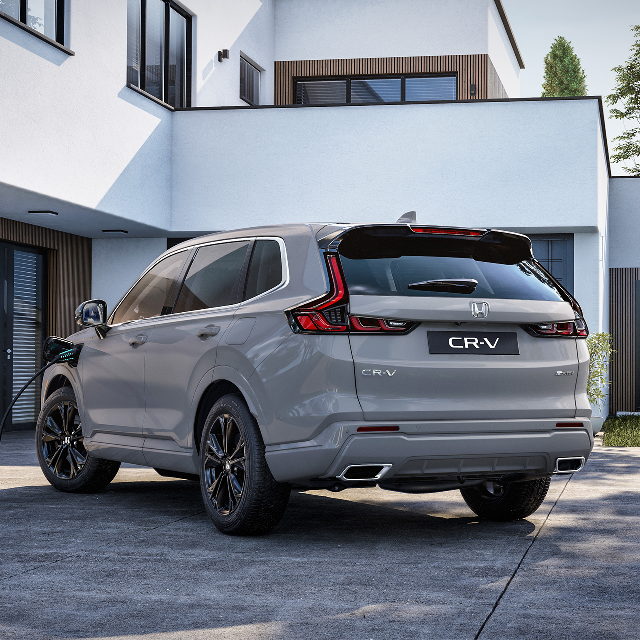 CR-V Plug in Hybrid SUV står parkerad utanför en byggnad. 