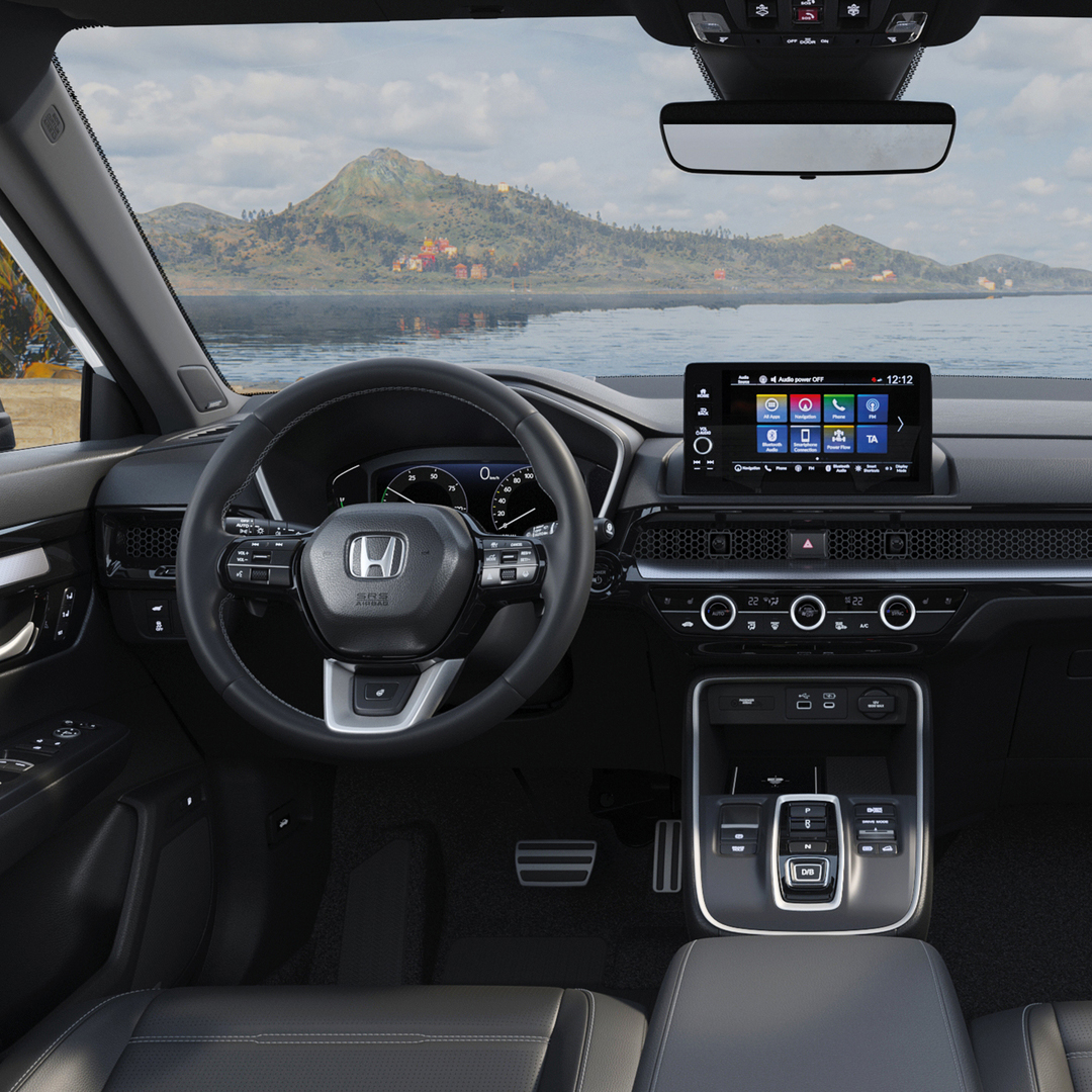 Interiörvy av en Honda CR-V, som visar infotainment systemet, växelväljaren och ratten.