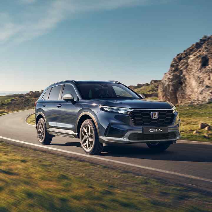 Vy snett framifrån av Honda CR-V Hybrid som kör i bergsmiljö.