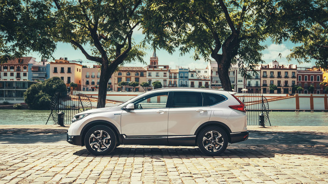 Sidovy vänd mot Honda CR-V Hybrid-bil i gatumiljö.