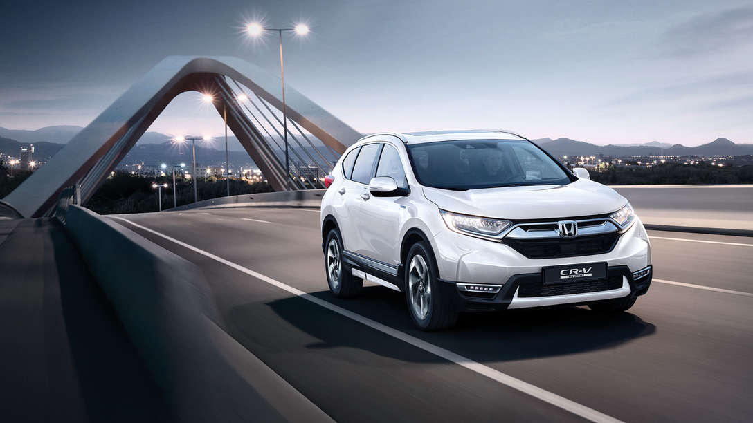 Trekvartsvy framifrån vänd mot Honda CR-V Hybrid i gatumiljö.