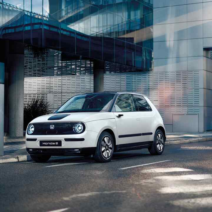 Honda e på gatan med byggnader i bakgrunden