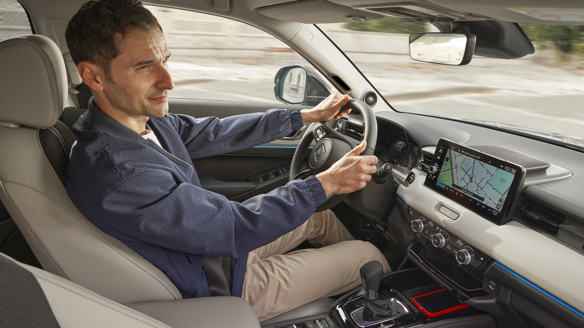 Interior view of a Honda vehicle showing the dashboard and center console. A large touchscreen display is visible, along with modern controls. The driver's seat and steering wheel are also in view.