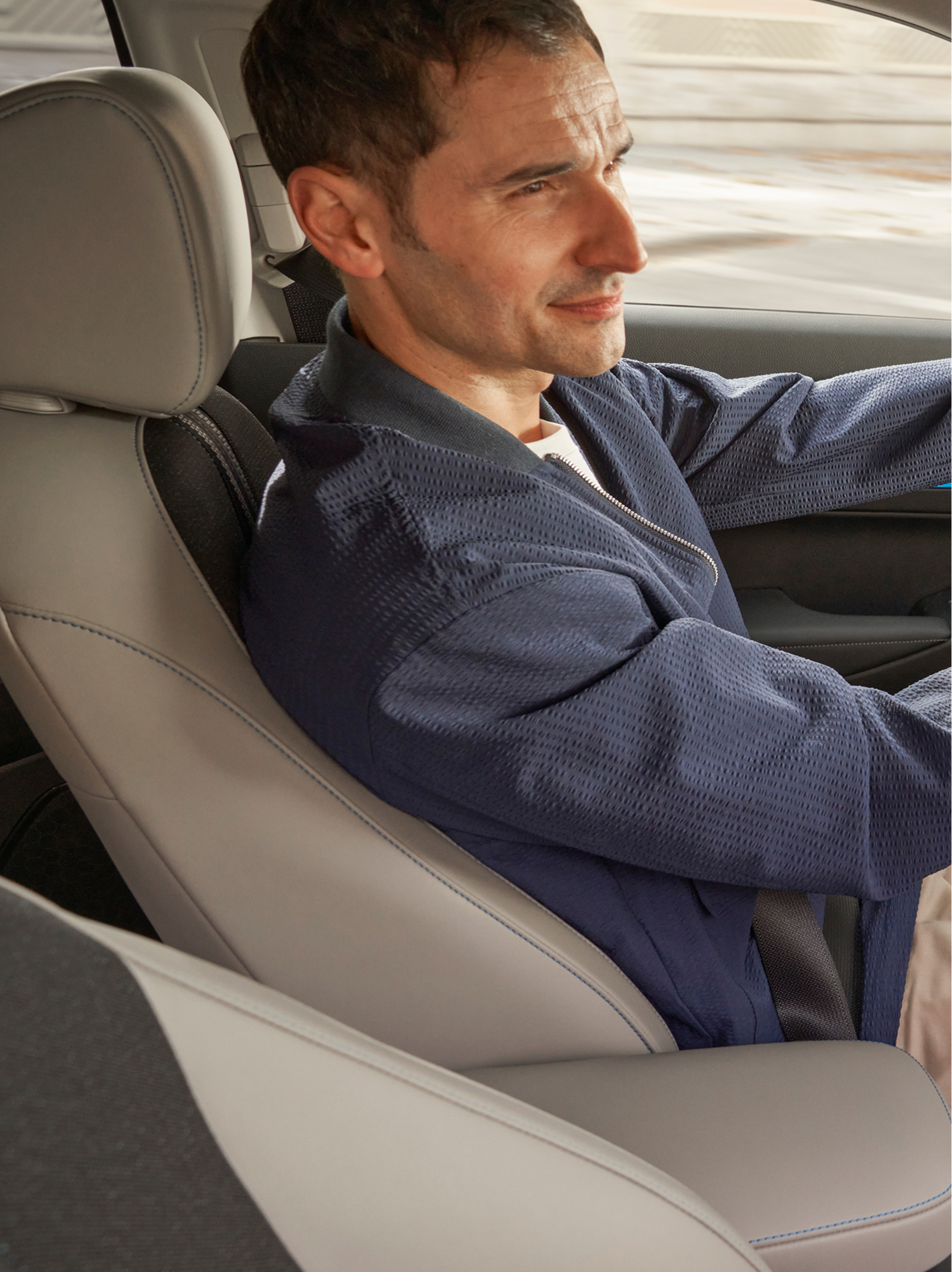 En förare sitter bakom ratten i en Honda HR-V, sedd från främre passagerarsätet, med instrumentbrädan och en navigationskarta som visas på mittskärmen.