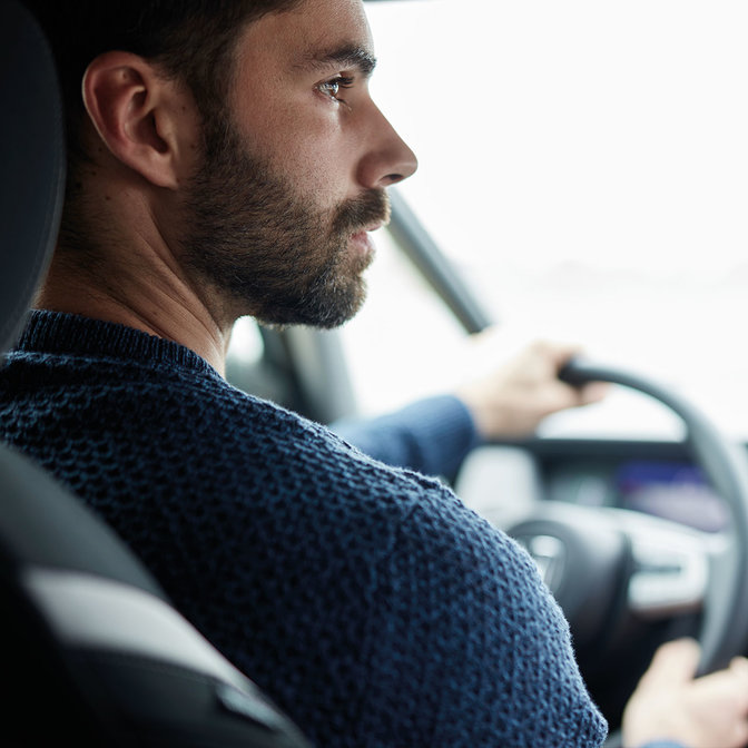 närbild på en man som kör en Honda Jazz