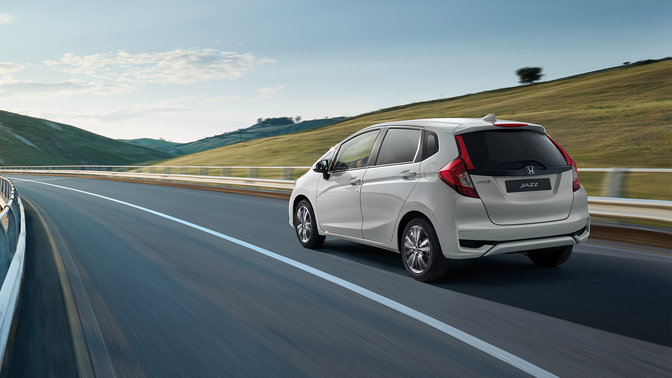 Trekvartsvy bakifrån av Honda Jazz Dynamic i lantlig miljö.