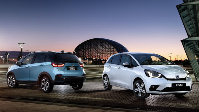 Trekvartsvy framifrån och bakifrån av två parkerade Honda Jazz nattetid