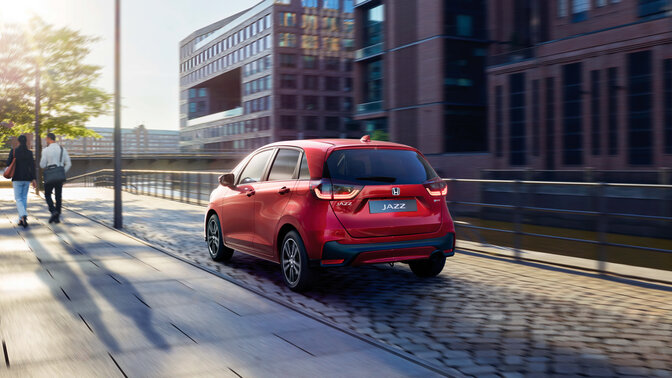 Vy snett framifrån av Jazz framför stadsbakgrund