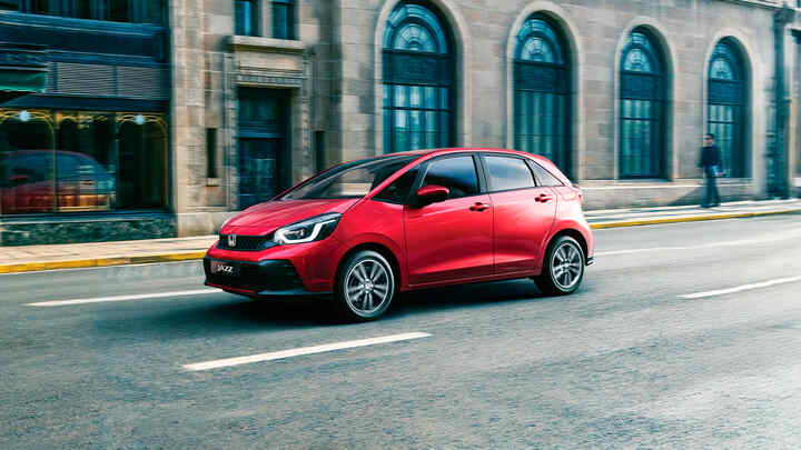 3/4 vy framifrån av Honda Jazz som kör i en stad.