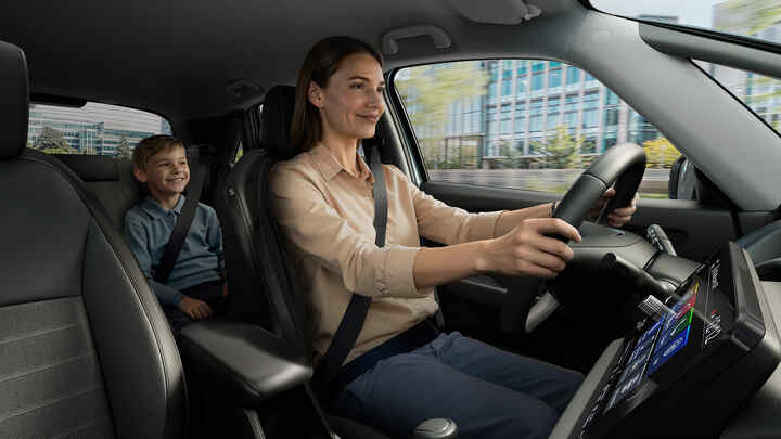 En kvinna som kör en Honda Jazz Hybrid, med ett barn i baksätet.