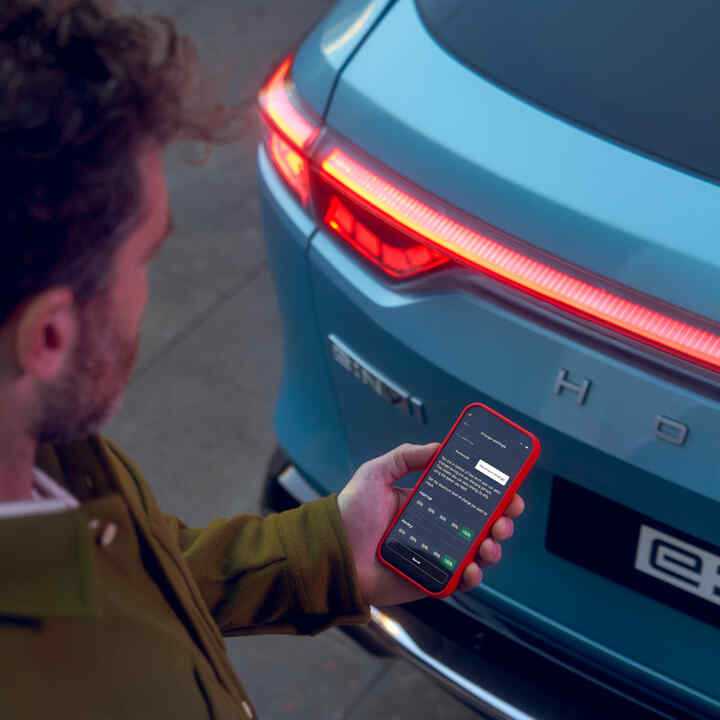 Närbild i appen My Honda+ av person som använder telefonen utanför en bil