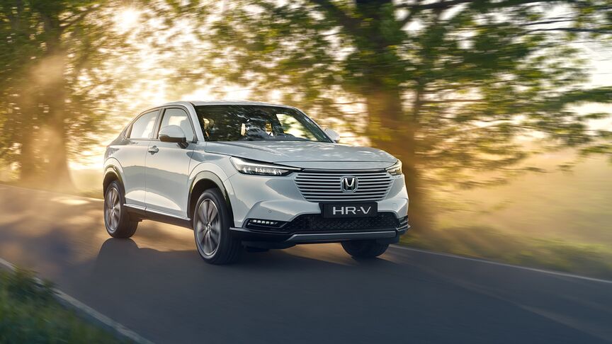 Vy snett framifrån av en HR-V Hybrid som kör på en landsväg