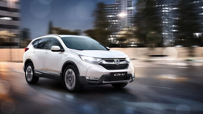 Vy snett framifrån av en HR-V Hybrid som kör på en landsväg