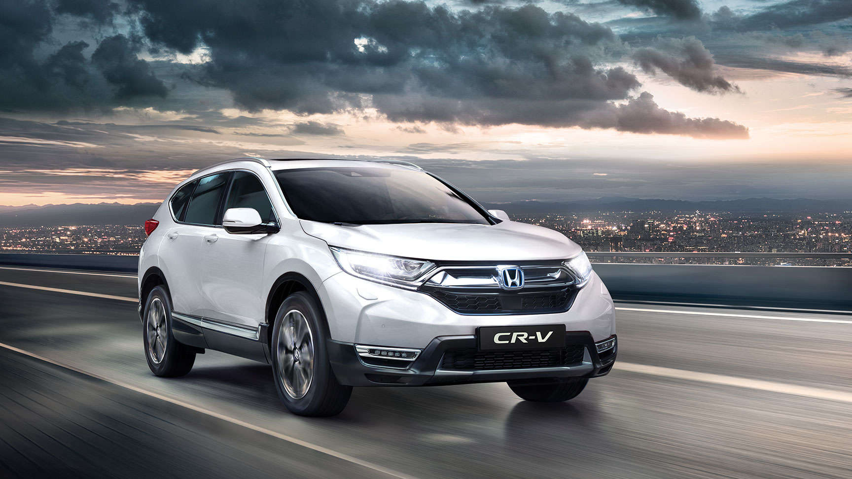 Vy snett framifrån av Honda CR-V med tänt helljus