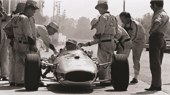 Vy framifrån av Formel 1-bil från Honda från 1960-talet med förare och ingenjörer.