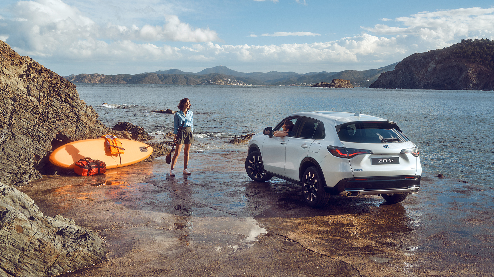 Vit ZR-V vid havet med kvinna och kanot