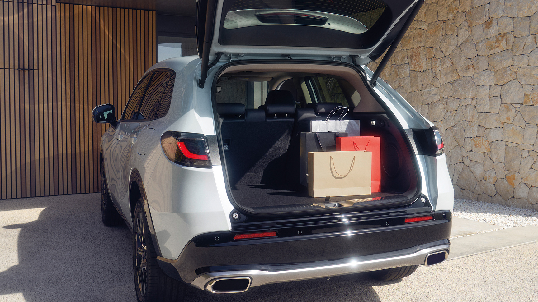 Vit ZR-V med öppen baklucka på uppfart