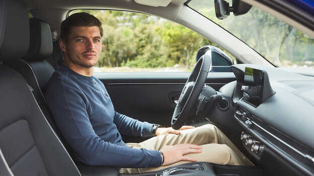 Max Verstappen sitter inne i ZR-V Hybrid SUV på en parkering.