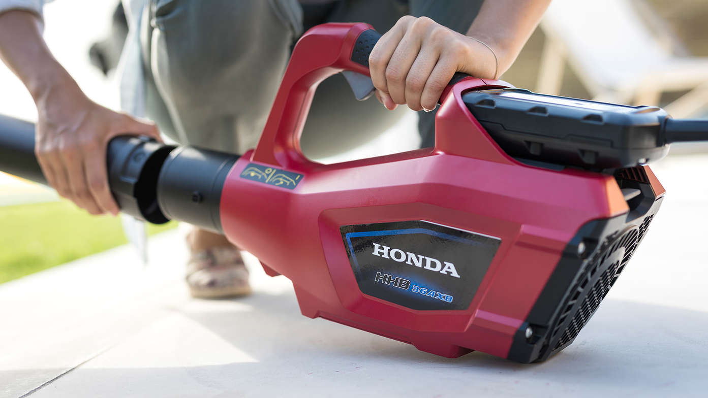 Närbild på en person som byter munstycke på Hondas batteridrivna lövblåsare.