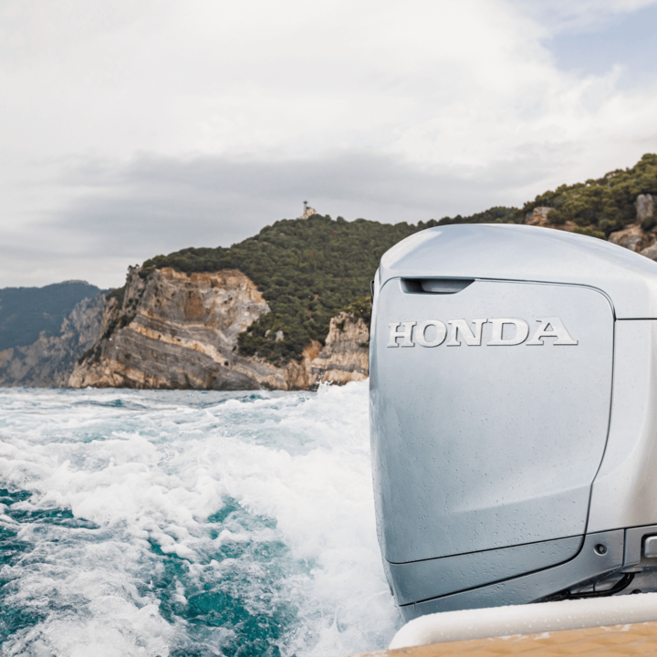 Båt som kör med BF350-motor i havs- och bergsscenario.