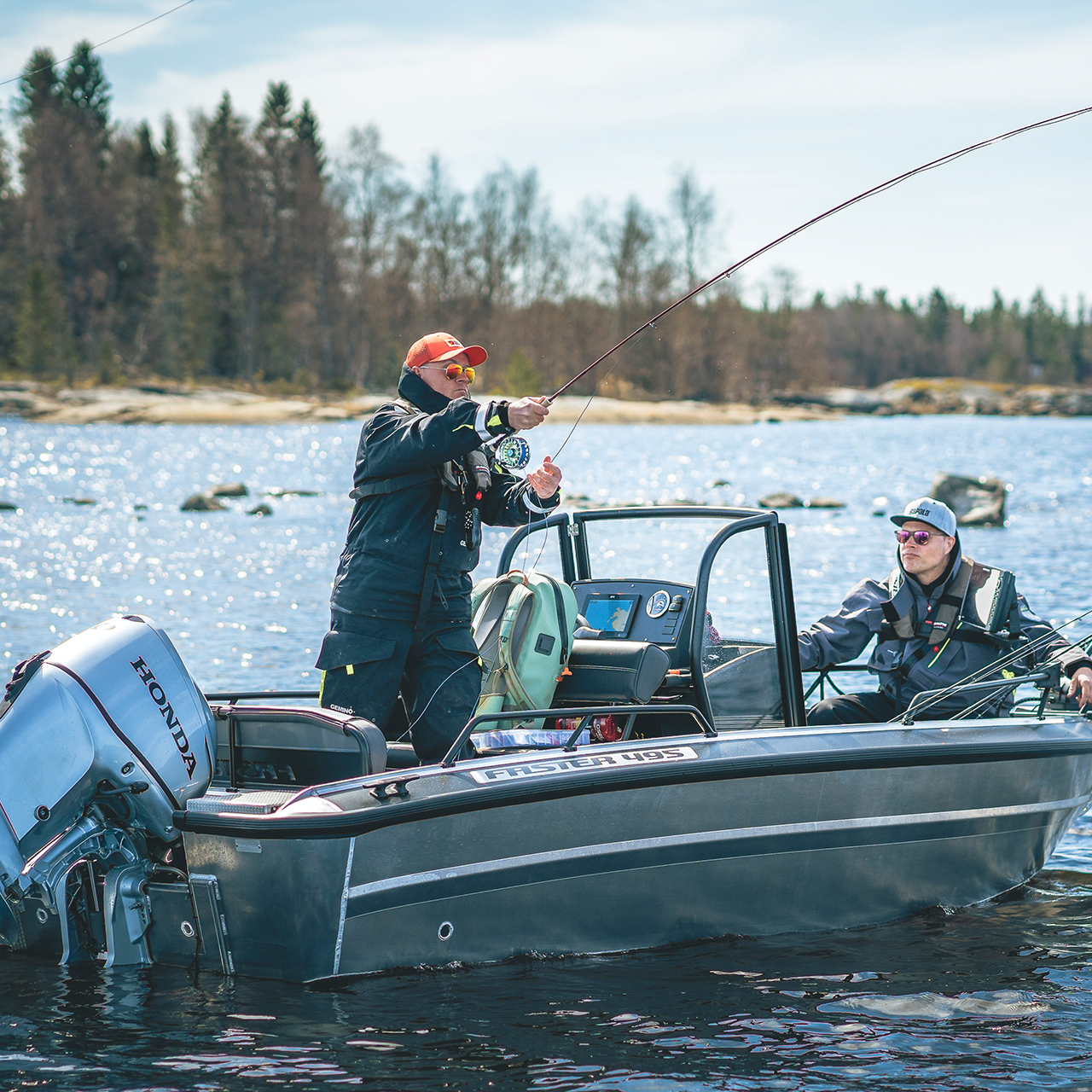 Män som fiskar från en båt med Honda BF30-motor i sjöområde.