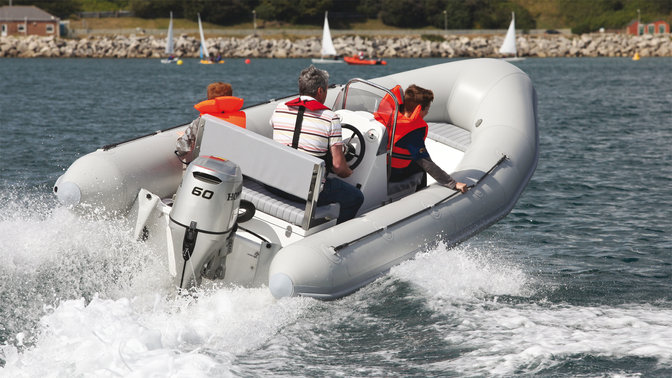 Båt med Honda-motor, körd av modeller, kustmiljö.