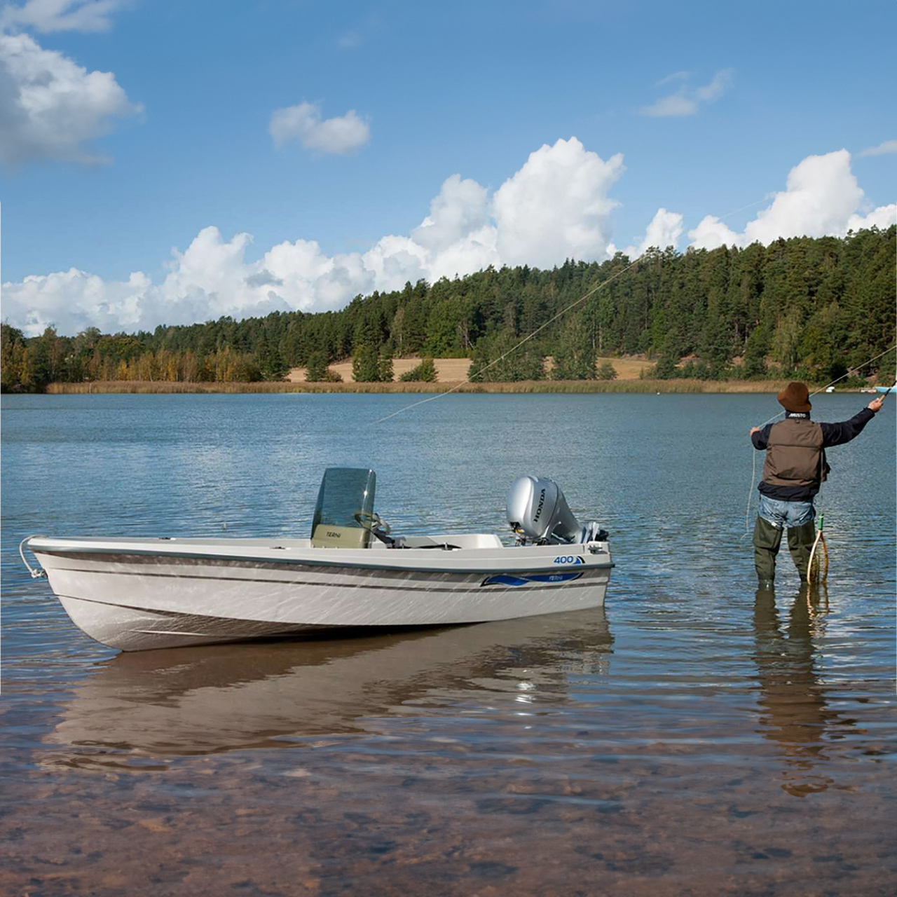 Modell som fiskar på sjön, med båt i närheten som visar upp BF8-10-motorn.