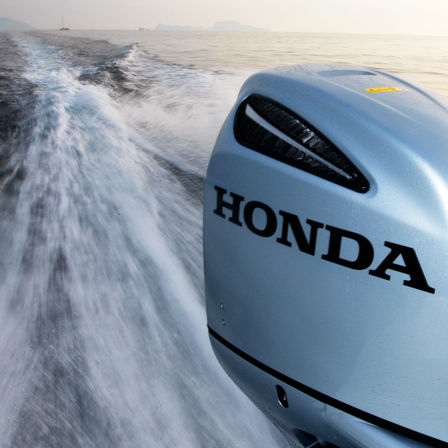 Närbild på en Honda-motor, kustmiljö.