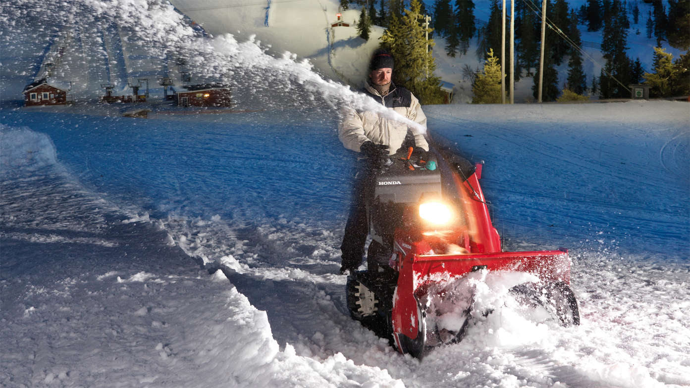 Hybridsnöslunga som körs av modell, i bergstrakt.