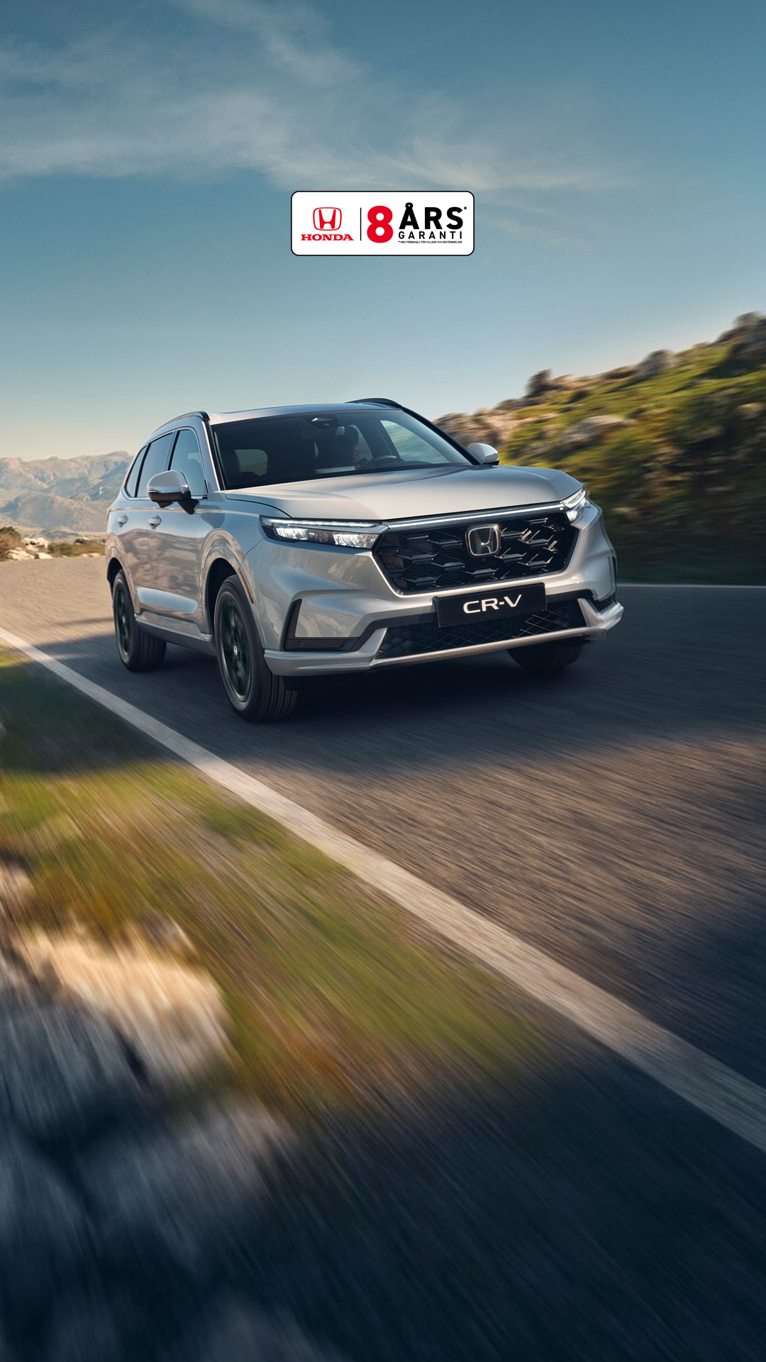 CR-V Plug in Hybrid SUV står parkerad utanför en byggnad. 