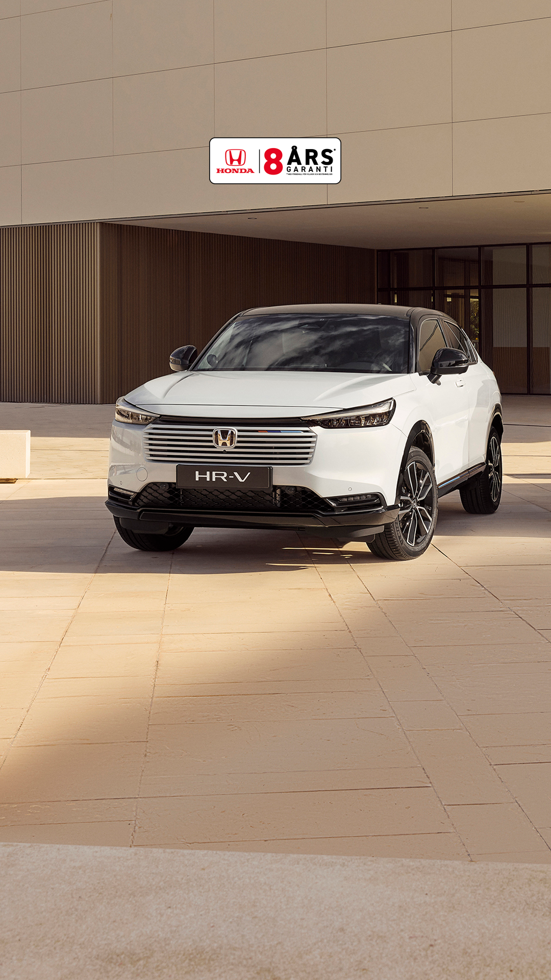 Two Honda HR-V SUVs parked outside a modern building, shown from front and rear angles—one in white facing forward and one in silver facing away.