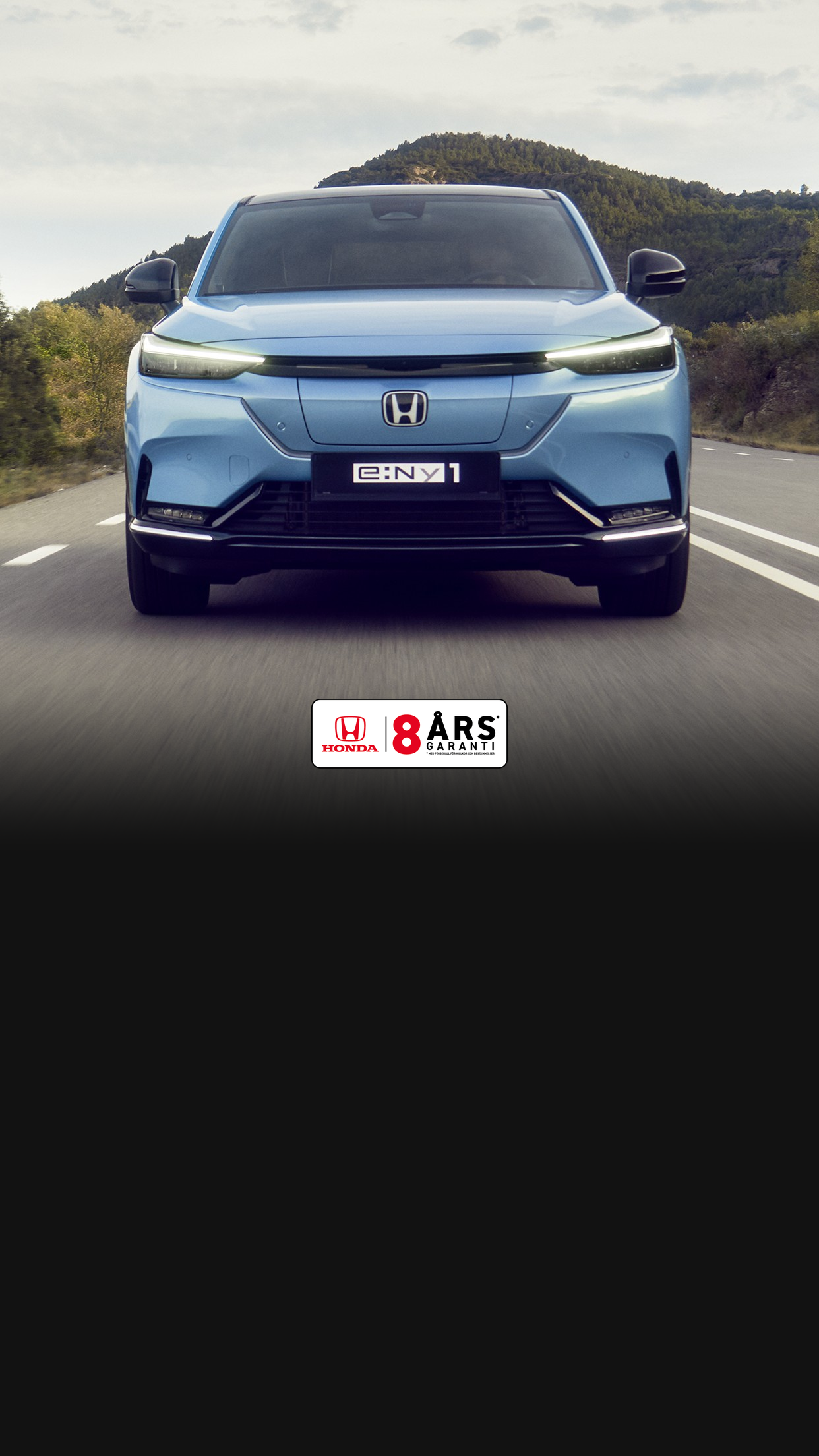 Vy framifrån av en Honda e:Ny1 i ett bergigt område. 